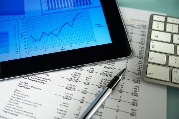 A tablet with a graph with budget paperwork