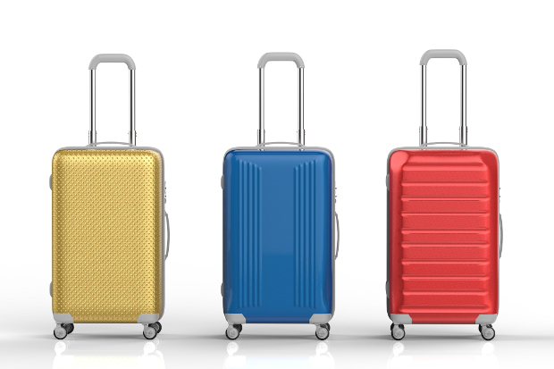 Three rolling suitcases of different bright colours