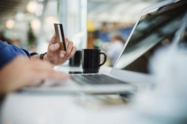 Person looking at a computer screen while holding a membership card