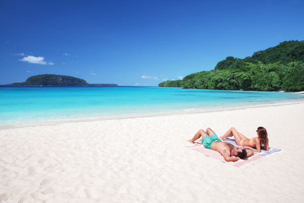 A couple relax on Champagne Beach in Vanuatu.