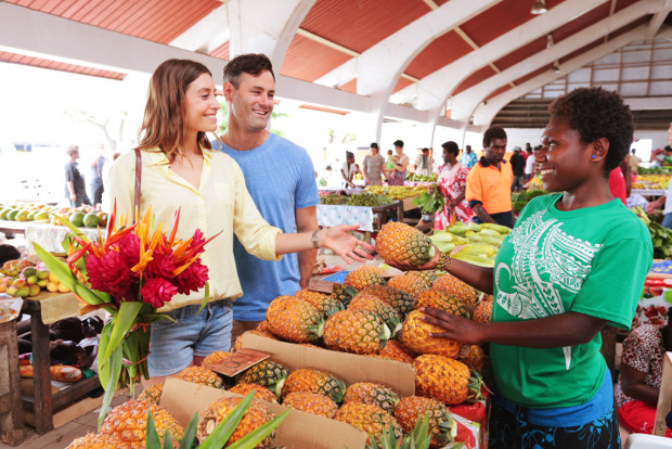 A couple check out a pineapple stall at the Port Vila market in Vanuatu.