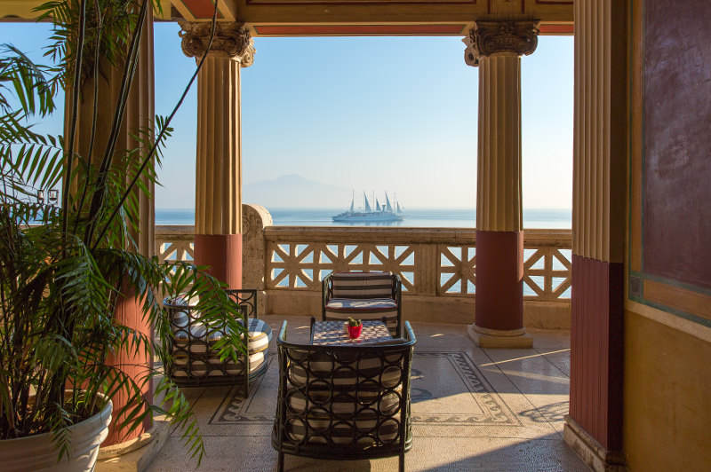 balcony overlooking gulf of naples with ship on horizon