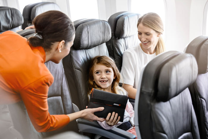 jetstar cabin crew giving young girl amenity kit