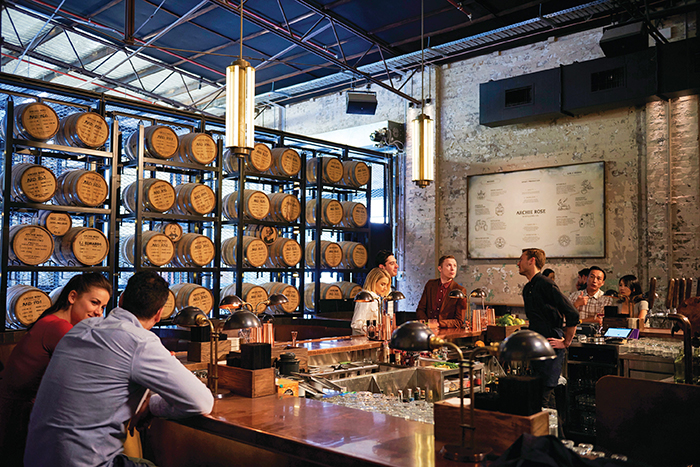A wall of ageing whisky barrels flank the bar at Archie Rose Distillery & Bar.