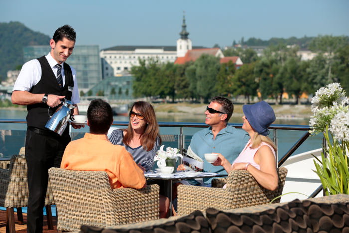 group having breakfast on sun deck of ama prima APT river cruise ship