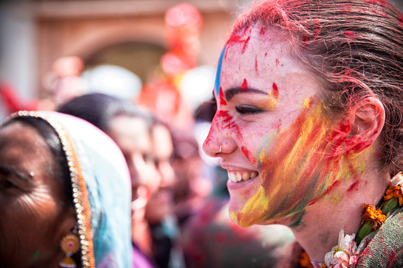 A young woman is covered in coloured powder during the Holi festival in India.