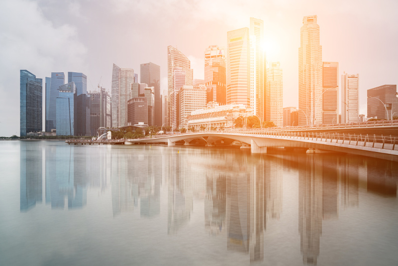 The Singapore skyline against a peachy-golden sky.