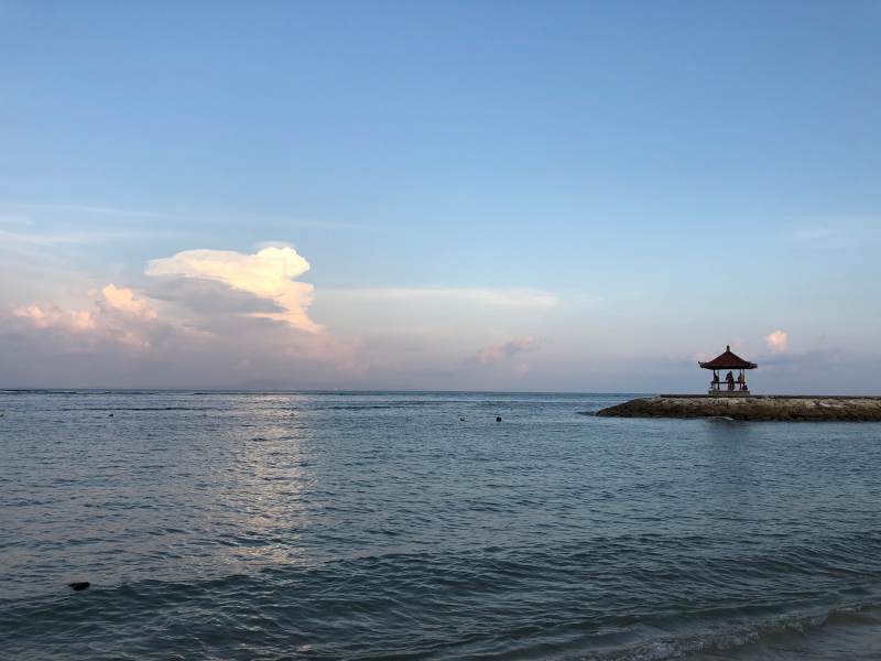 Sunset at Nusa Dua Beach with small temple in the background