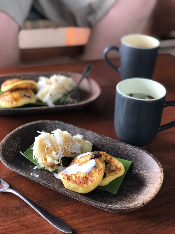 Two small pancakes and another sweet treat with shredded coconut. Tea in the background