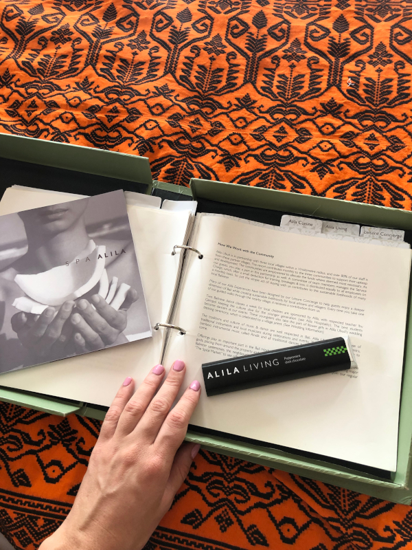 Hotel compendium with page open about how Alila Ubud works with the community and spa menu