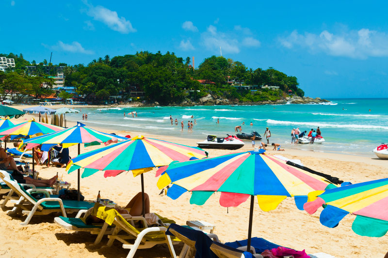 Umbrellas, sun loungers and jet skis dot Kata Beach in Phuket, Thailand.