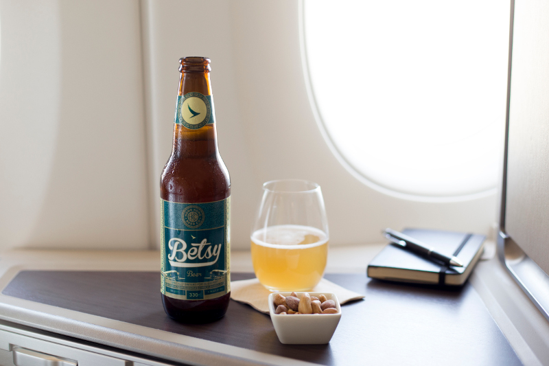 A bottle of Betsy bear and some snacks in a Cathay Pacific aircraft.