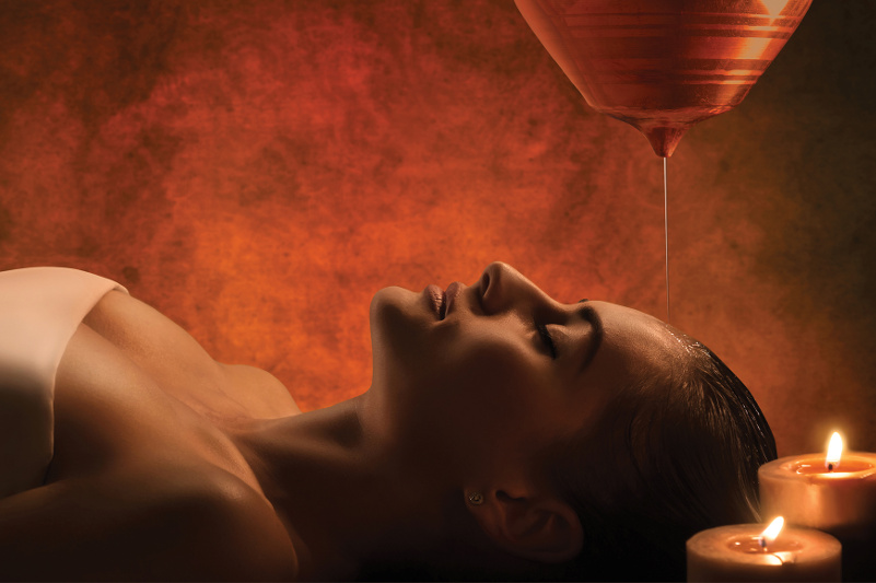 woman laying down with oil running over her head in massage parlour woman laying down with oil running over her head in massage parlour