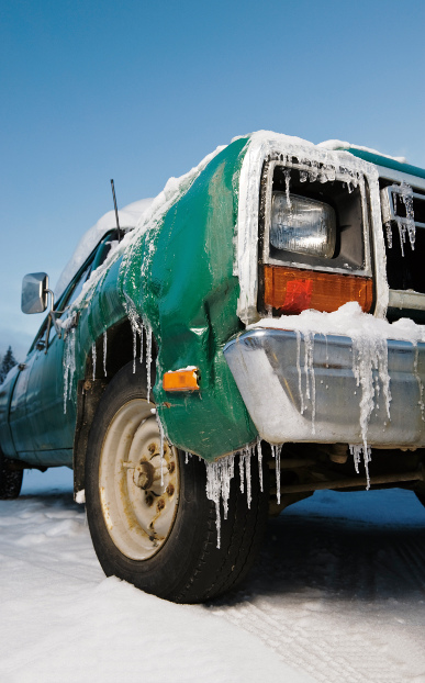 A truck with icicles hanging off the bumper