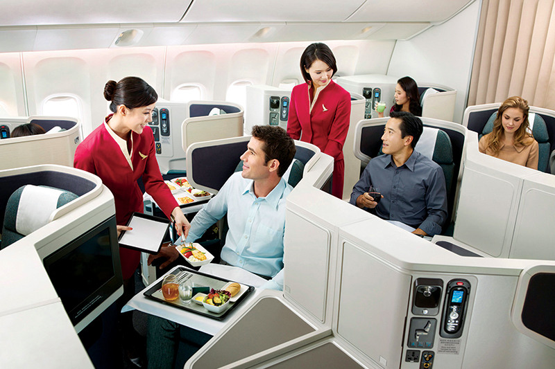 A Cathay Pacific attendant serving a meal