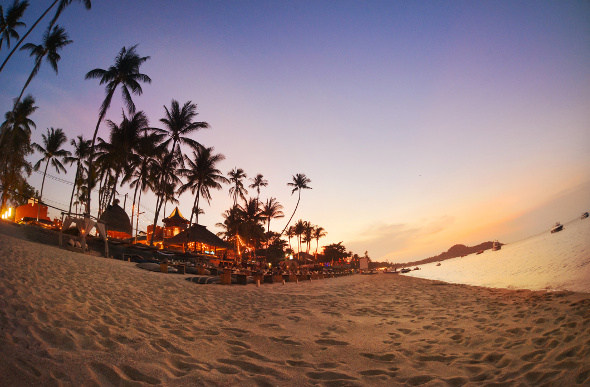 A cafe by the beach as the sun sets in Koh Samui, Thailand.