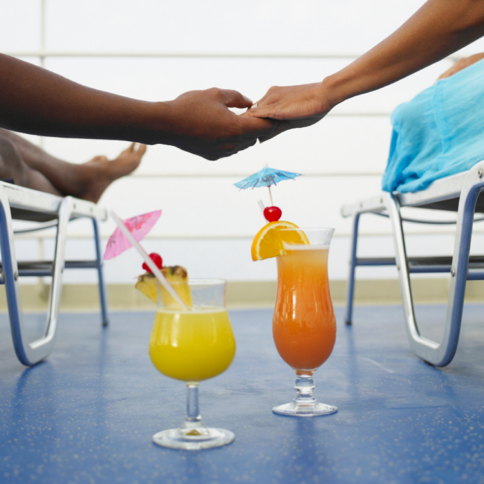 Hands holding on cruise deck with cocktails