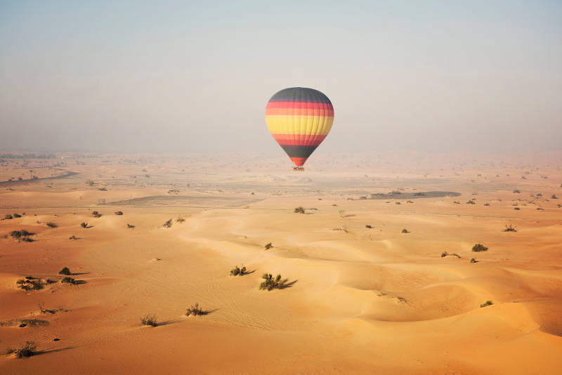 hot air balloon over the dunes and desert near dubai.
