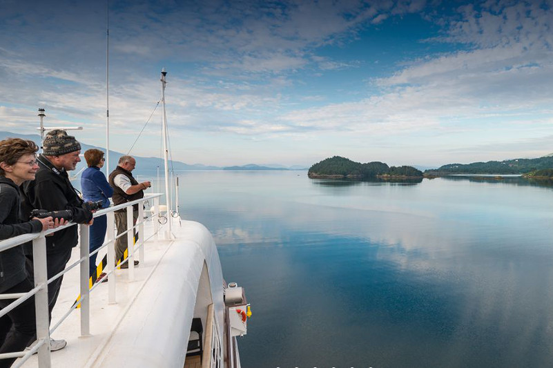 People looking out over ship balcony.