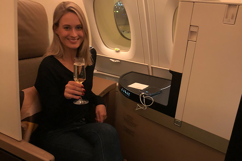 A female with a champagne glass in business class cabin