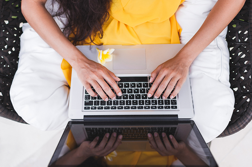 Women working on laptop in a tropical garden setting