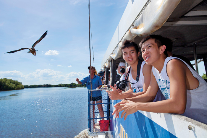 tourists keep an eye out for river creatures