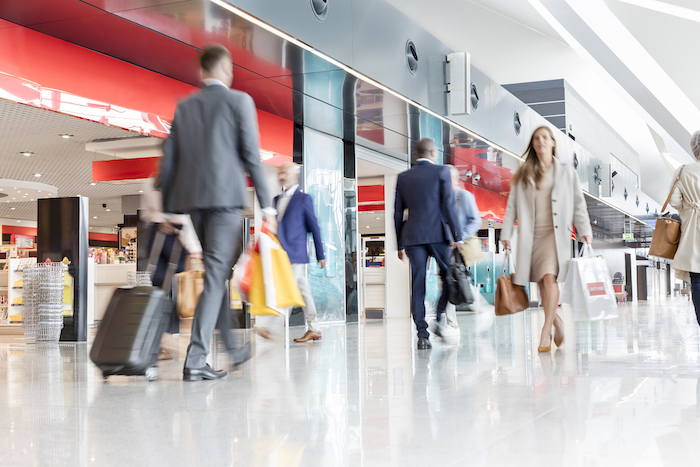 busy travellers in an airport - frequent flyer points - flight centre business travel