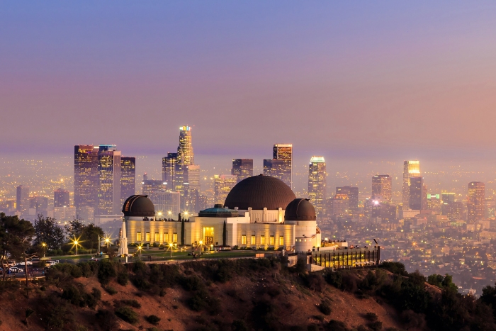 Griffith Observatory sits overlooking the twinkling lights of LA at dusk. LA's top 10 must-have experiences - Griffiths Observatory