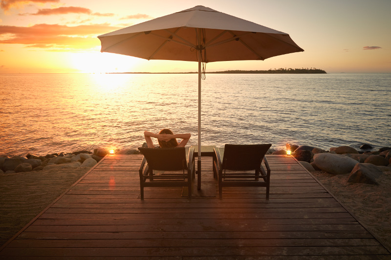 Woman relaxing on deck in Fiji at sunset