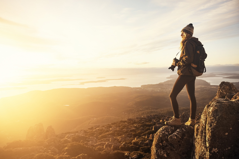 Woman with camera on mountain top