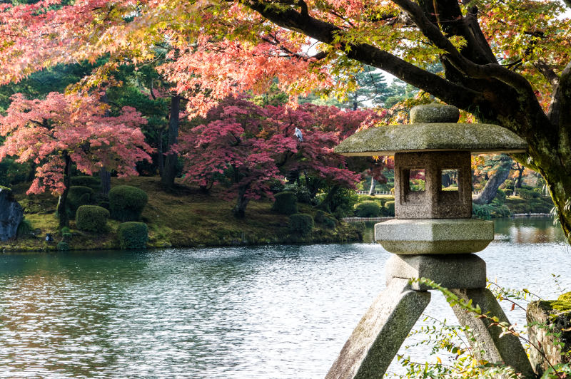 Stone sculpture overlooking water in Kenroku-en Garden in Kanazawa, Japan