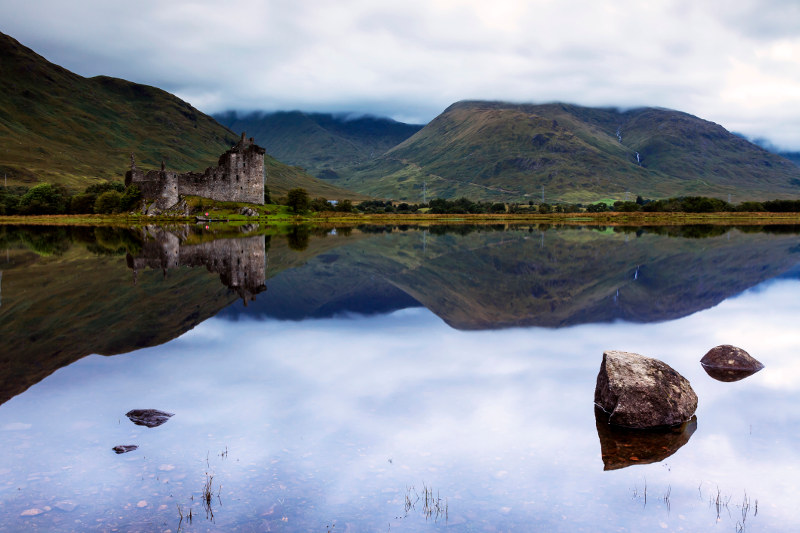 castle with dark lake in foreground in scottish highlands, loch ness