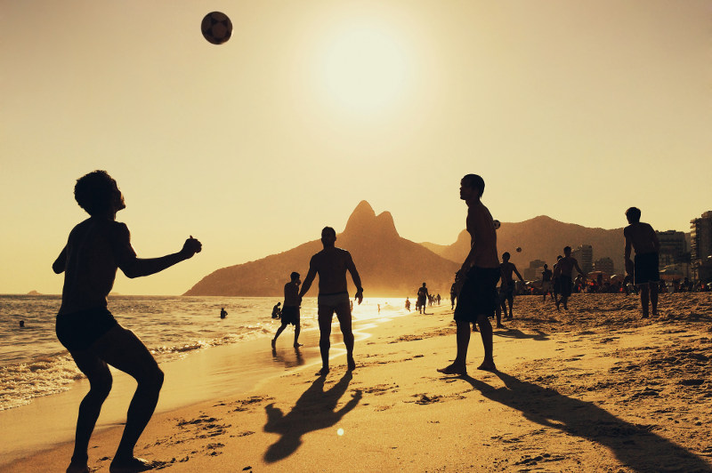 men playing football on Ipanema beach, rio de janeiro, brazil