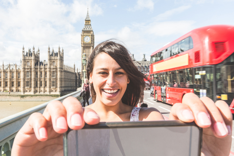 Woman taking selfie on bridge in London, United Kingdom
