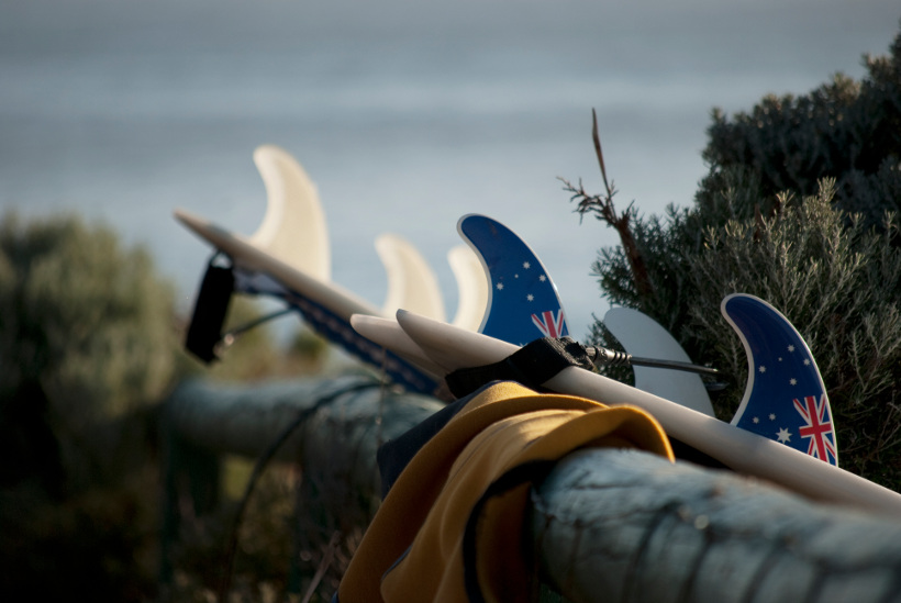 surfboards leaning against fence