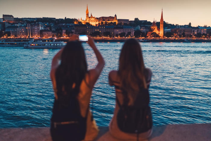 two women on banks of river at dusk in europe