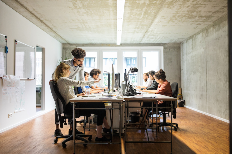 Business people discussing over computer in creative office