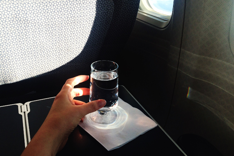 A glass of water on an airplane tray table