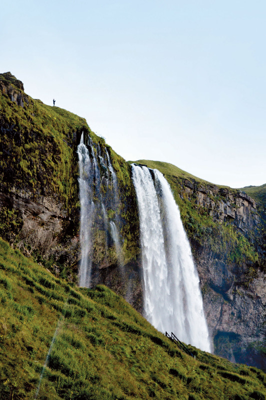 man at top of waterfall iceland