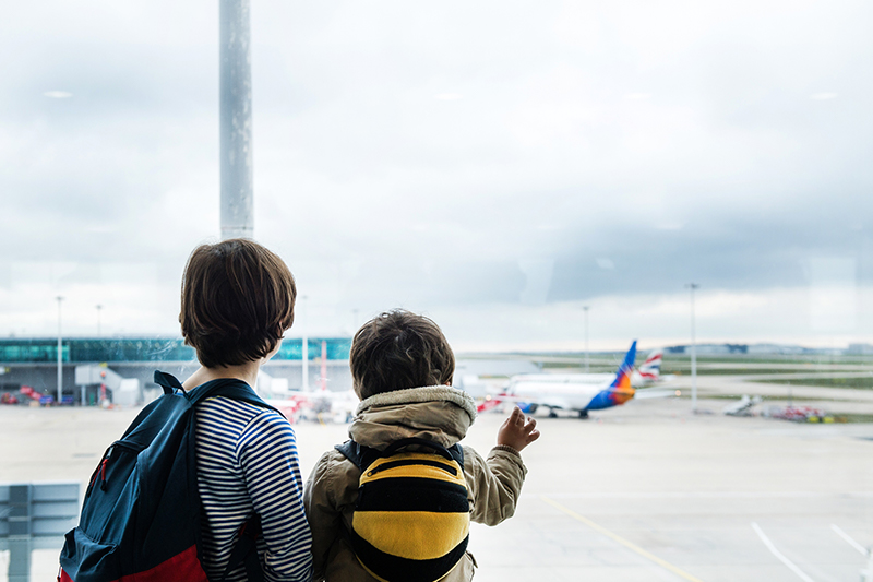 two boys watch planes at the airport