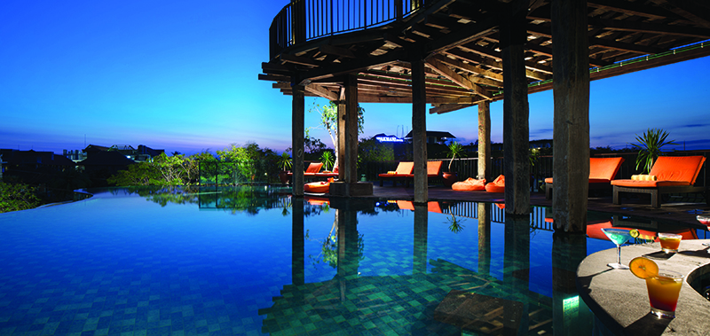 Pool that looks towards the pool deck with orange deck chairs