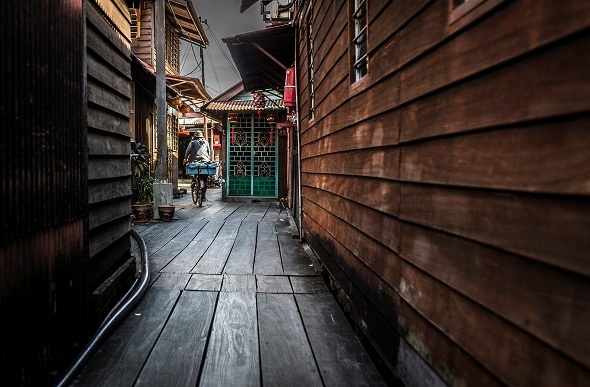 man cycles down alleyway in former chinese settlement in georgetown penang