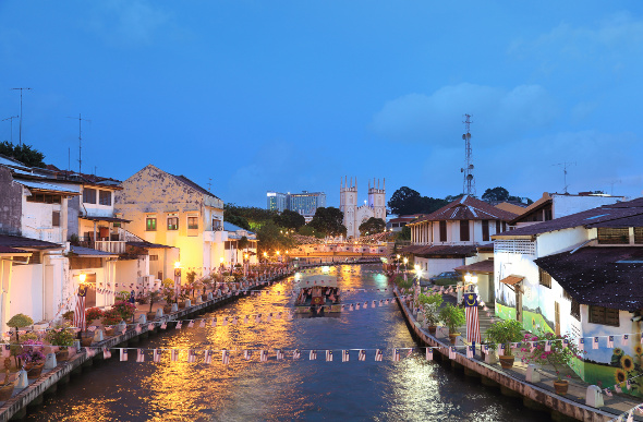 The twinkling lights of Malacca on either side of the river.