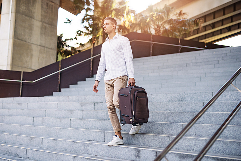 Man carrying suitcase down stairs