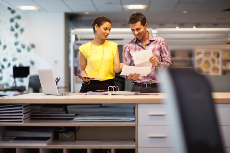 Two professionals speaking to one another in an office