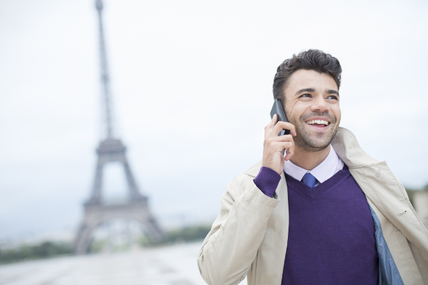A smiling businessman in front of the Eiffel Tower.