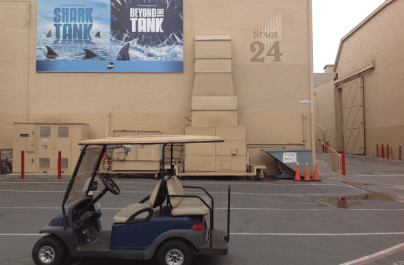 A buggy in the Sony Pictures back lot, with Shark Tank posters in the background.