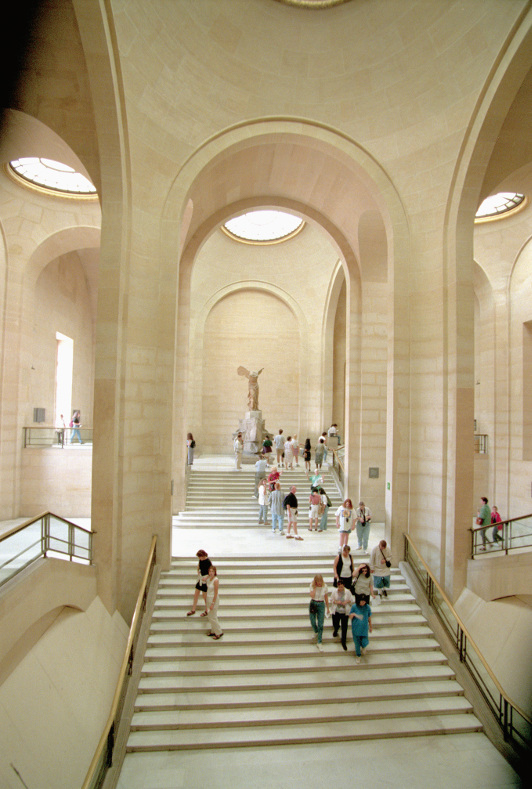 The statue of the Winged Victory of Samothrace stands at the top of a flight of stairs at the Louvre, in Paris.