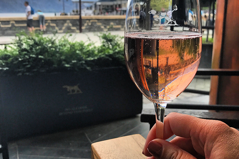 Holding a glass of sparkling wine in Queenstown.