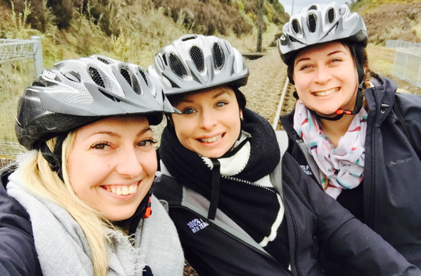 A group of girls smiling and wearing helmets